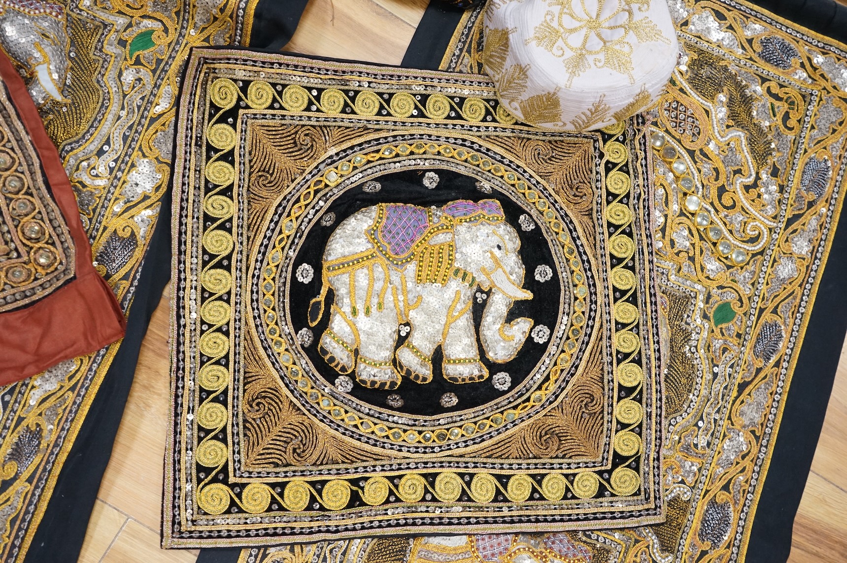 A quantity of mostly 20th century Middle Eastern and Indian woven and printed textiles and a peacock feather fan (2 boxes).